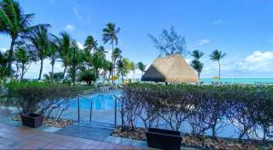 a resort with a swimming pool and palm trees at Golden Beach Flat Recife in Recife