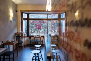 un ristorante con tavoli e sgabelli di fronte a una finestra di Aida Charming Rooms a Roma