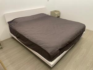 1 cama en un dormitorio con manta marrón en Puli House, en Puli