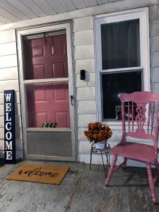a pink chair sitting outside of a house with a door at Hite Home in Akron