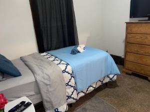a bedroom with a bed with a teddy bear on a blue blanket at Hite Home in Akron