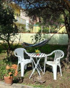 2 chaises, une table et un hamac sous un arbre dans l'établissement Casa Vacanze "Villa Severina" IUN R6166 R6692, à Carbonia