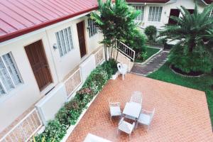 RQS Hostel في تاكلوبان: اطلالة هوائية على منزل به كراسي وشرفة