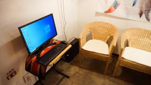 a computer on a desk with a keyboard and chairs at Space ARA in Seoul