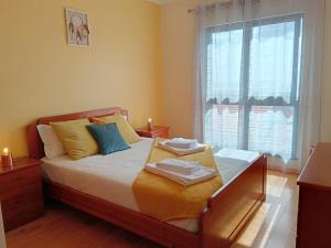 a bedroom with a bed with two towels on it at Casa da Vila in Santa Cruz