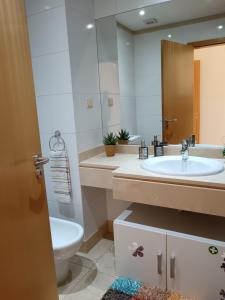 W łazience znajduje się umywalka, toaleta i lustro. w obiekcie Casa da Vila w mieście Santa Cruz