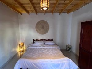 1 dormitorio con 1 cama y una luz en la pared en Oro Guesthouse, en Dahab