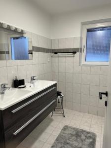 ein Bad mit einem Waschbecken und einem Spiegel in der Unterkunft Apart7 in Lermoos