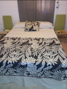 a bed with a black and white blanket on it at Habitación En La Casita de Marley in Villa Carlos Paz