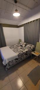 a bedroom with a bed and two chairs at Habitación En La Casita de Marley in Villa Carlos Paz