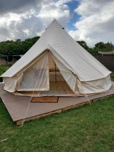 a large white tent sitting in a yard at North Shore Glamping / Camping Laie, Oahu, Hawaii in Laie