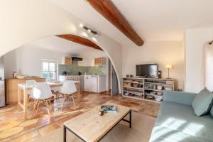 a living room with a couch and a table at Mas Oréa Sous la glycine in Gordes