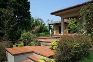 une maison avec une terrasse en bois dans un jardin dans l'établissement B&B La Casa di Angela, à Cusago