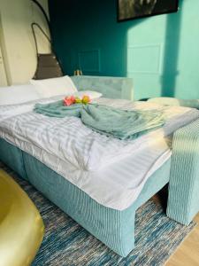 Una cama con una manta y flores. en Penthouse, Sonnenbalkon, Netflix en Saarbrücken