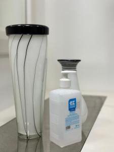 a bottle of detergent sitting next to two glass vases at غرفة نوم للاسترخاء والراحة in Al Madinah