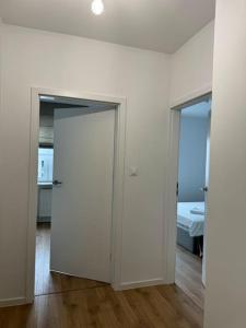 a white room with two doors and a bed at Glamour Apartment in Ochota in Warsaw