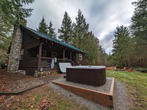 a log cabin with a hot tub in front of it at River Rock Chalet :: Hot Tub, Pets, Stevens Pass in Skykomish