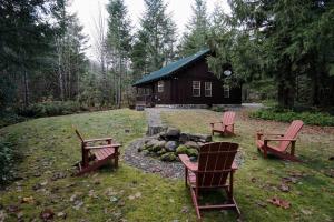 a group of chairs sitting in front of a cabin at River Rock Chalet :: Hot Tub, Pets, Stevens Pass in Skykomish