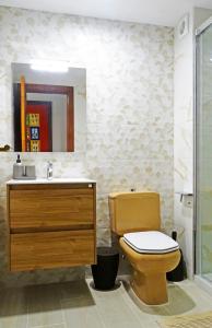 a bathroom with a toilet and a sink and a mirror at Santa Cruz de Tenerife, acogedor, céntrico, garaje in Santa Cruz de Tenerife