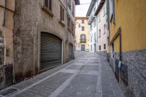 Alzano Lombardo的住宿－La Vecchia Filanda 4 - Alzano Lombardo - by Host4U，大楼一侧的一条小巷,两扇车库门