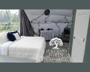 ボルケーノにあるVolcano Forest Resortのベッドルーム1室(白いベッド1台、木の敷物付)