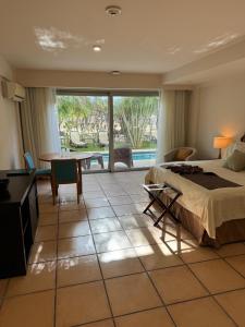 1 dormitorio con cama, mesa y escritorio en GOLF CORONADO LUXURY MANGO SUITE PRIVATE POOL FEE INCLUDED en Playa Coronado
