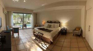 um quarto com uma cama, uma mesa e uma cadeira em GOLF CORONADO LUXURY MANGO SUITE PRIVATE POOL FEE INCLUDED em Playa Coronado
