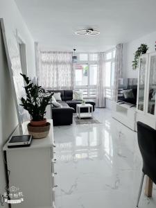 a white living room with a couch and a table at San Eugenio in Adeje