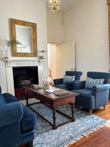 sala de estar con sillas azules y mesa de centro en The Customs House Port MacDonnell en Port MacDonnell