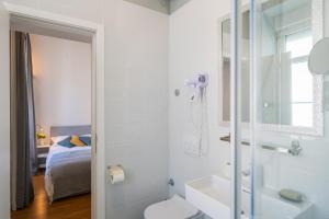a bathroom with a toilet and a sink and a bed at Berry Berry Studios by Flat White in Zagreb