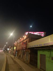 un bâtiment avec un panneau de néon en haut de celui-ci la nuit dans l'établissement HOTEL EL CASTILLO MANTA2, à Manta