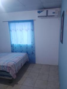1 dormitorio con cama y cortina azul en HOTEL EL CASTILLO MANTA2 en Manta