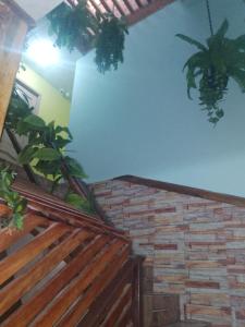 una habitación con plantas en la pared y una pared de ladrillo en HOTEL EL CASTILLO MANTA2 en Manta