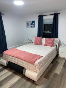 1 dormitorio con 1 cama grande con almohadas rojas en Remodeled Townhouse in Watertown, en Watertown