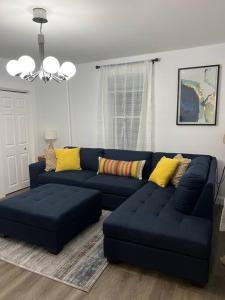 sala de estar con sofá azul y almohadas amarillas en Remodeled Townhouse in Watertown, en Watertown