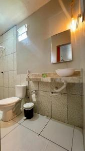 a bathroom with a toilet and a sink at Pousada Recanto das Orquídeas in Barreirinhas