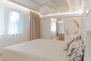 a white bedroom with a large bed and a mirror at 252 m² luxury 4 bedroom house in the pine-forest in Vilnius