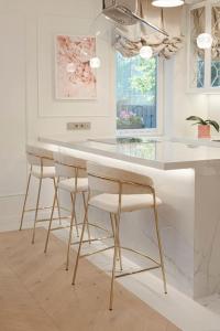 a kitchen with a white counter and stools at 252 m² luxury 4 bedroom house in the pine-forest in Vilnius +27 photos
