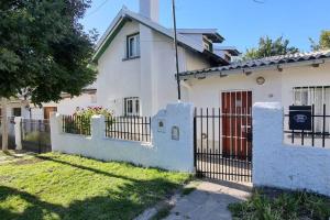a white house with a gate and a fence at Casa completa para 5 personas. in San Carlos de Bariloche