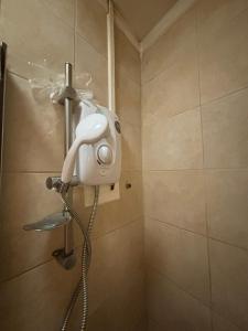 a shower with a blow dryer in a bathroom at Studios/ Bedsitter living unit -Ilford in Ilford