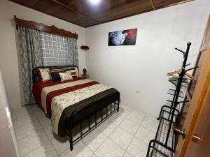 een slaapkamer met een bed en een foto aan de muur bij Departamento Ángeles del Arenal #2 in Fortuna
