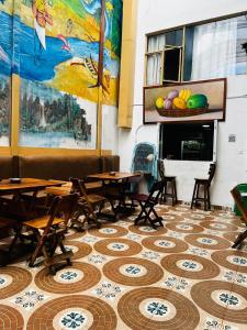 a room with tables and a painting on the wall at Four Season Hostel in Bogotá