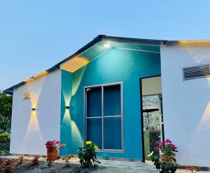 una casa blu e bianca con dei fiori davanti di Reserva La Esperanza a Vergara