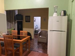 a kitchen with a refrigerator and a table and chairs at Hostel do Lucca in Porto Alegre