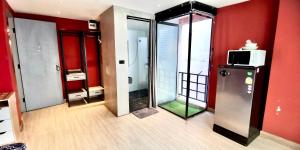 a room with red walls and a refrigerator and a microwave at Hash Silom Apartment @ Silom Soi 3 in Bangkok