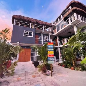 une maison sur la plage avec des palmiers devant dans l'établissement Costa Nube, à Caye Caulker