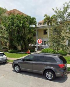 un coche aparcado en un estacionamiento frente a una casa en Wonderful Gables bedroom, en Miami