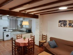 cocina y sala de estar con mesa y sofá en Masía de San Juan - Casas rurales con piscina en masía fortificada, en Segorbe