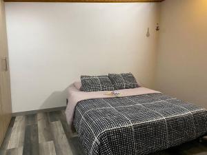 a bedroom with a bed with a black and white blanket at Alojamiento/Lodging:El Indio Ese in Sopo