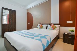 a bedroom with a large bed in a room at Super OYO 77994 The G Stay in Chinchiwad
